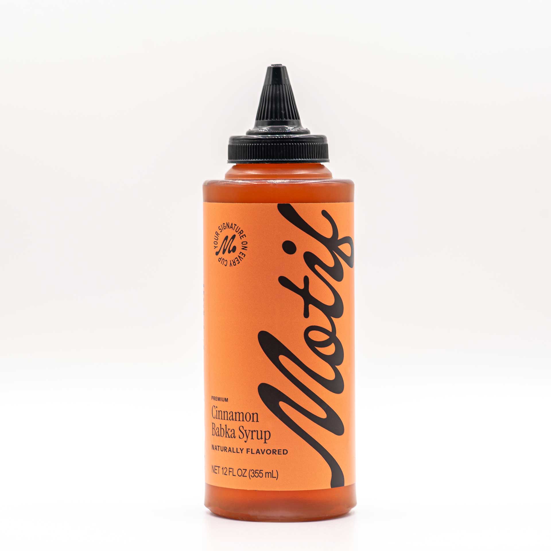 Bottle of Motif Premium Cinnamon Babka Syrup with an orange label and black twist precision cap.