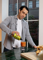 Man squeezing Pistachio Syrup into a beverage using the black twist precision cap.