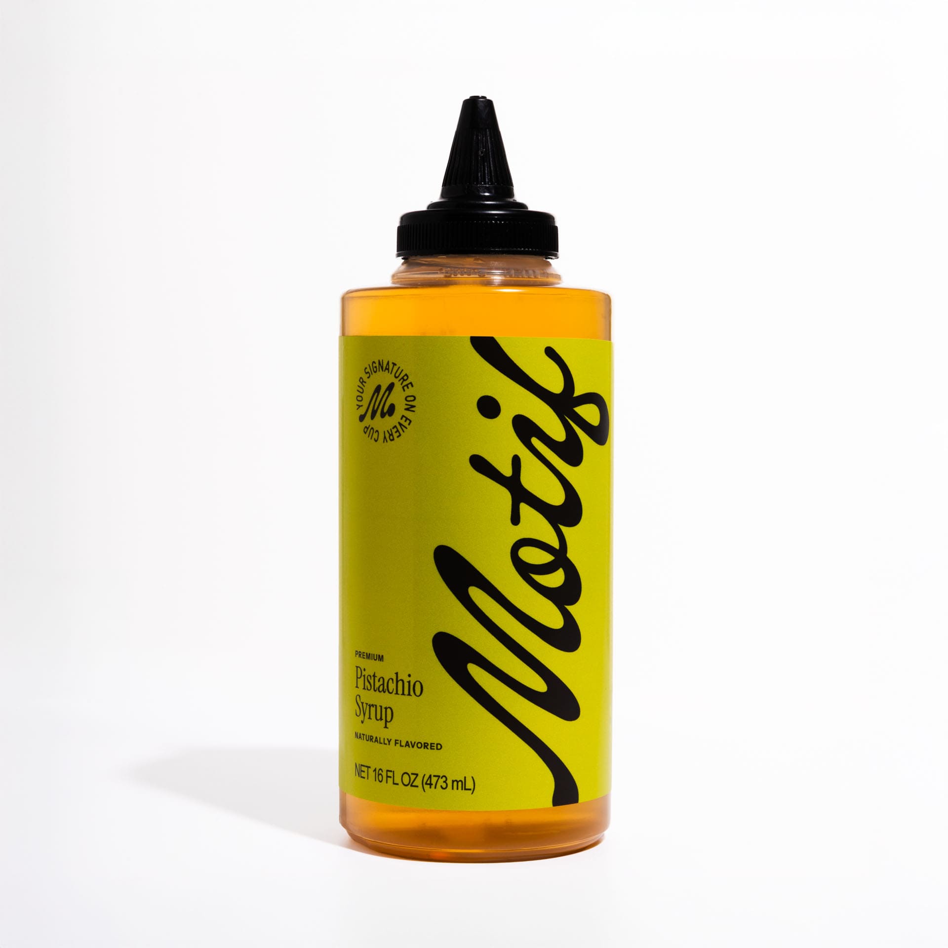 Bottle of Motif Premium Pistachio Syrup with a pistachio green label and black twist precision cap.